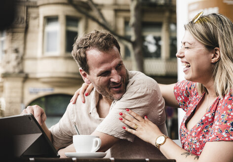 Glückliches Paar mit Tablet in einem Straßencafé - UUF14310