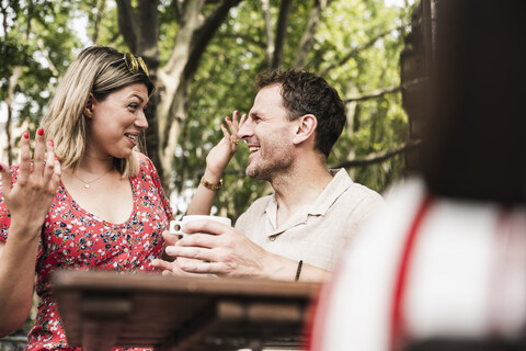 Happy couple talking at an outdoor cafe stock photo