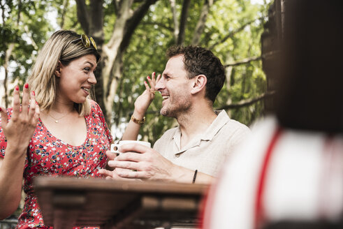 Glückliches Paar im Gespräch in einem Straßencafé - UUF14316