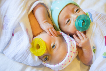 Twin baby sister and brother sucking on comforter - ISF14184