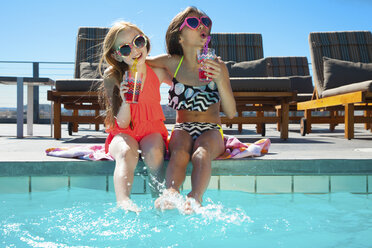 Mädchen sitzen am Pool mit Getränken - ISF14192