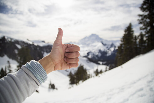 Weibliche Hand macht Daumen hoch vor schneebedeckter Aussicht, Mount Baker, Washington, USA - ISF14222