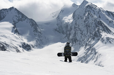 Junger männlicher Snowboarder beim Bergaufgehen, Obergurgl, Österreich - CUF34075