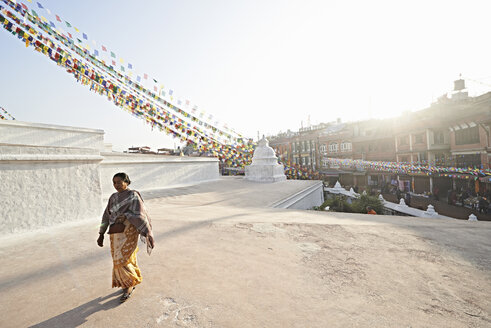 Ältere Frau beim Spaziergang durch Boudhanath, Kathmandu, Nepal - CUF34097