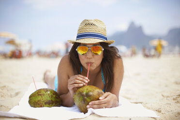 Porträt einer reifen Frau, die aus einer Kokosnuss trinkt, Strand von Ipanema, Rio De Janeiro, Brasilien - CUF34129