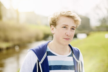 Portrait of teenage boy by rural river - CUF34136