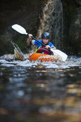 Mid adult man kayaking on river - CUF34252