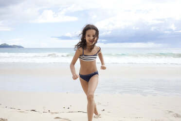 Girl running on beach in Seychelles - CUF34306