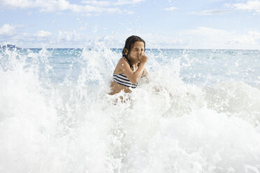 Girl playing in sea, holding nose - CUF34307