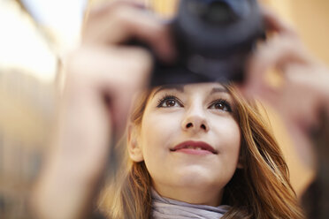 Nahaufnahme einer jungen Frau beim Fotografieren mit einer Digitalkamera - CUF34312