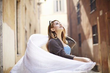 Junge Frau wirbelt ihren Schal auf der Straße, Rom, Italien - CUF34316