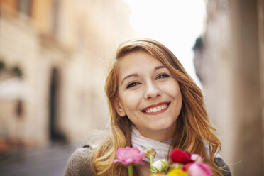 Lächelnde junge Frau mit einem Blumenstrauß - CUF34322