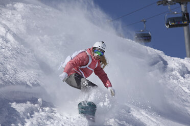 Junge Frau beim Snowboarden am steilen Berg, Hintertux, Tirol, Österreich - CUF34324