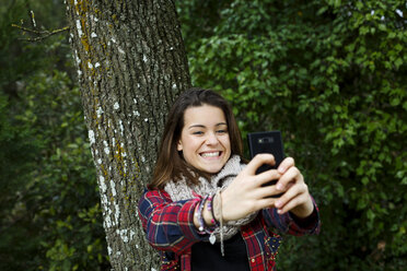 Teenage girl self-photographing in forest - CUF34361