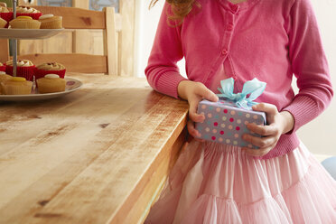 Girl holding birthday present, mid section - CUF34390