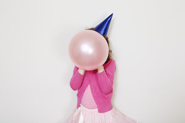 Mädchen hält rosa Luftballon vor dem Gesicht - CUF34391