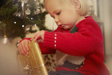 Kleines Mädchen mit Weihnachtsgeschenk, lizenzfreies Stockfoto