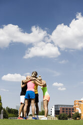 Exercise group huddled together in park - CUF34417
