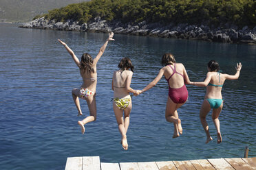 Four girls jumping from pier into the sea - CUF34424