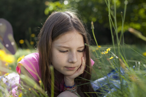 Girl lying in grass daydreaming stock photo