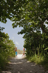 Junge und seine Schwester spielen auf einem bewaldeten Strandweg, Anna Maria Island, Florida, USA - ISF14384