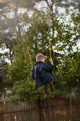 Junge schwingt hoch auf Gartenschaukel, Rückansicht - ISF14402