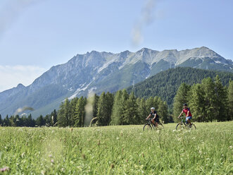 Austria, Tyrol, Mieming, couple riding bike in alpine scenery - CVF00860