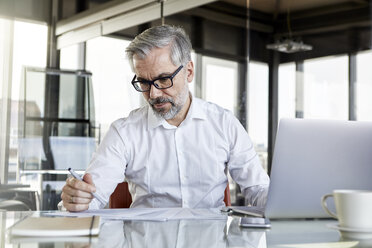 Geschäftsmann arbeitet am Schreibtisch im Büro - RBF06322