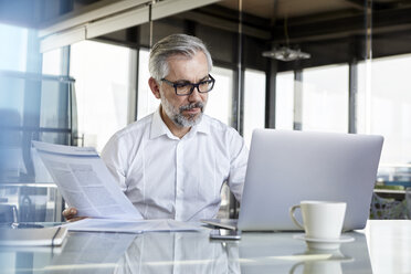 Geschäftsmann arbeitet am Schreibtisch im Büro - RBF06323