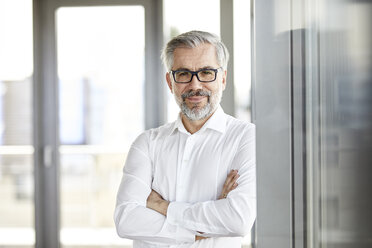 Portrait of smiling businessman standing at the window - RBF06337