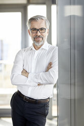 Portrait of smiling businessman standing at the window - RBF06340