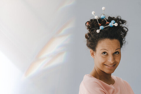 Junge Frau mit Molekülmodell im Haar, lizenzfreies Stockfoto