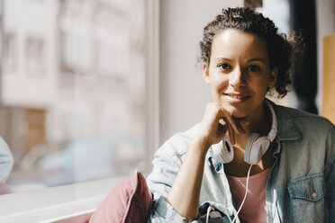 Young woman with headphones, working in coworking space - KNSF04093