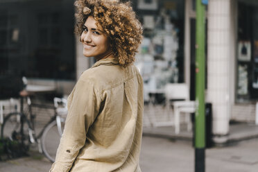 Woman in the city, walking away, smiling - KNSF04107