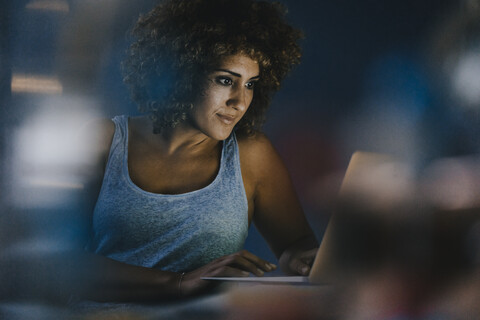 Frau macht Überstunden in ihrem neu gegründeten Unternehmen, lizenzfreies Stockfoto