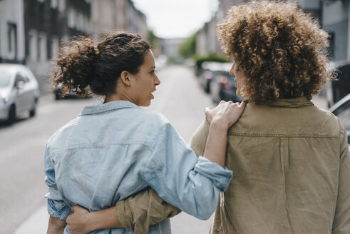 Beste Freunde beim Spaziergang in der Stadt, Arm in Arm, Rückansicht - KNSF04121