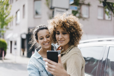 Beste Freunde machen Selfies mit einem Smartphone in der Stadt - KNSF04124