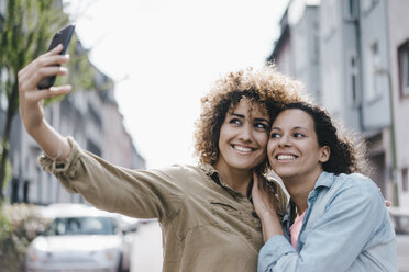 Beste Freunde machen Selfies mit einem Smartphone in der Stadt - KNSF04126