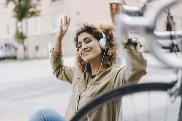 Woman in the city listening music with headphones - KNSF04138