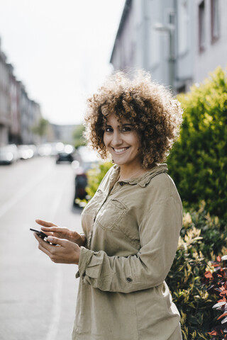 Frau in der Stadt mit Smartphone, lizenzfreies Stockfoto