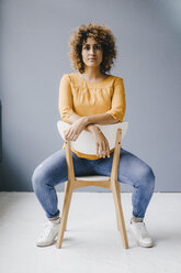 Woman sitting on chair, looking determined - KNSF04177