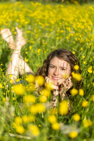 Young woman lying on flower meadow stock photo