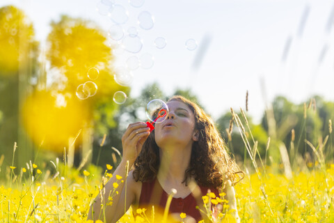 Young woman making soap bubbles stock photo