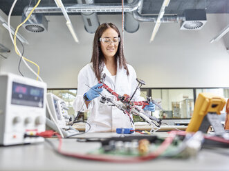 Female technician working in research laboratory, developing drone - CVF00886