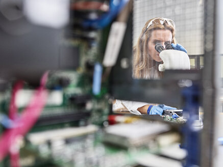 Technikerin bei der Arbeit mit dem Mikroskop im Forschungslabor - CVF00888