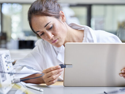 Technikerin bei der Arbeit im Forschungslabor, Tablet und USB-Stick - CVF00890