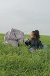 Kleines Mädchen mit Origami-Elefant auf Wiese - PSTF00124