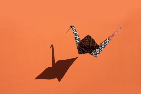 Origami-Kranich, orangefarbener Hintergrund, Schatten, Kopierraum - PSTF00136