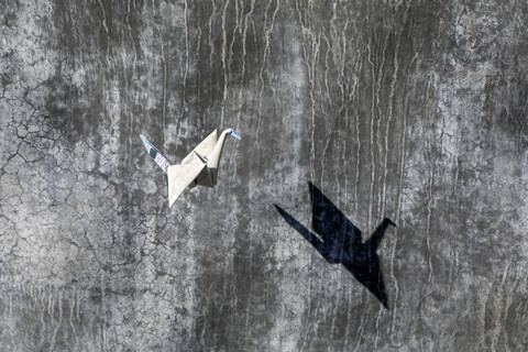 Origami-Kranich fliegend, Betonwand, lizenzfreies Stockfoto