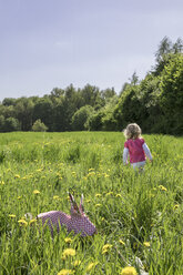 Kleines Mädchen und Origami-Kaninchen auf der Wiese - PSTF00166